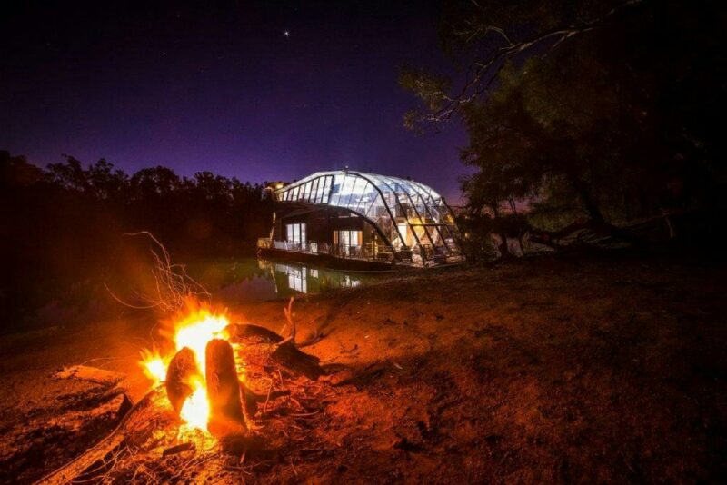 a night shot of houseboat with a fire pit in front
