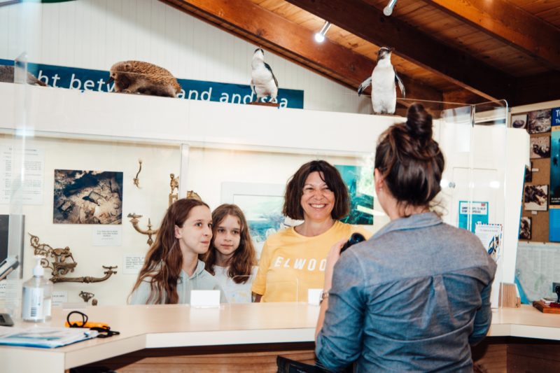 Visitors being served at the counter of the Port Campbell Visitor Information Centre