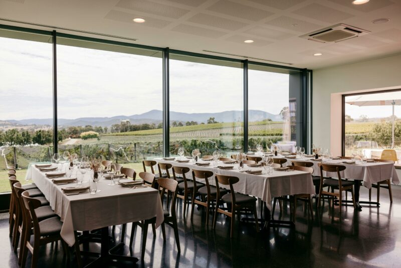 A view of Oakridge Restaurant with a large window overlooking vineyard and mountains.