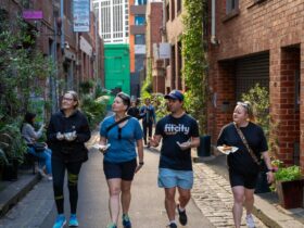 Image of four people walking down a Melbourne laneway with donuts in hand