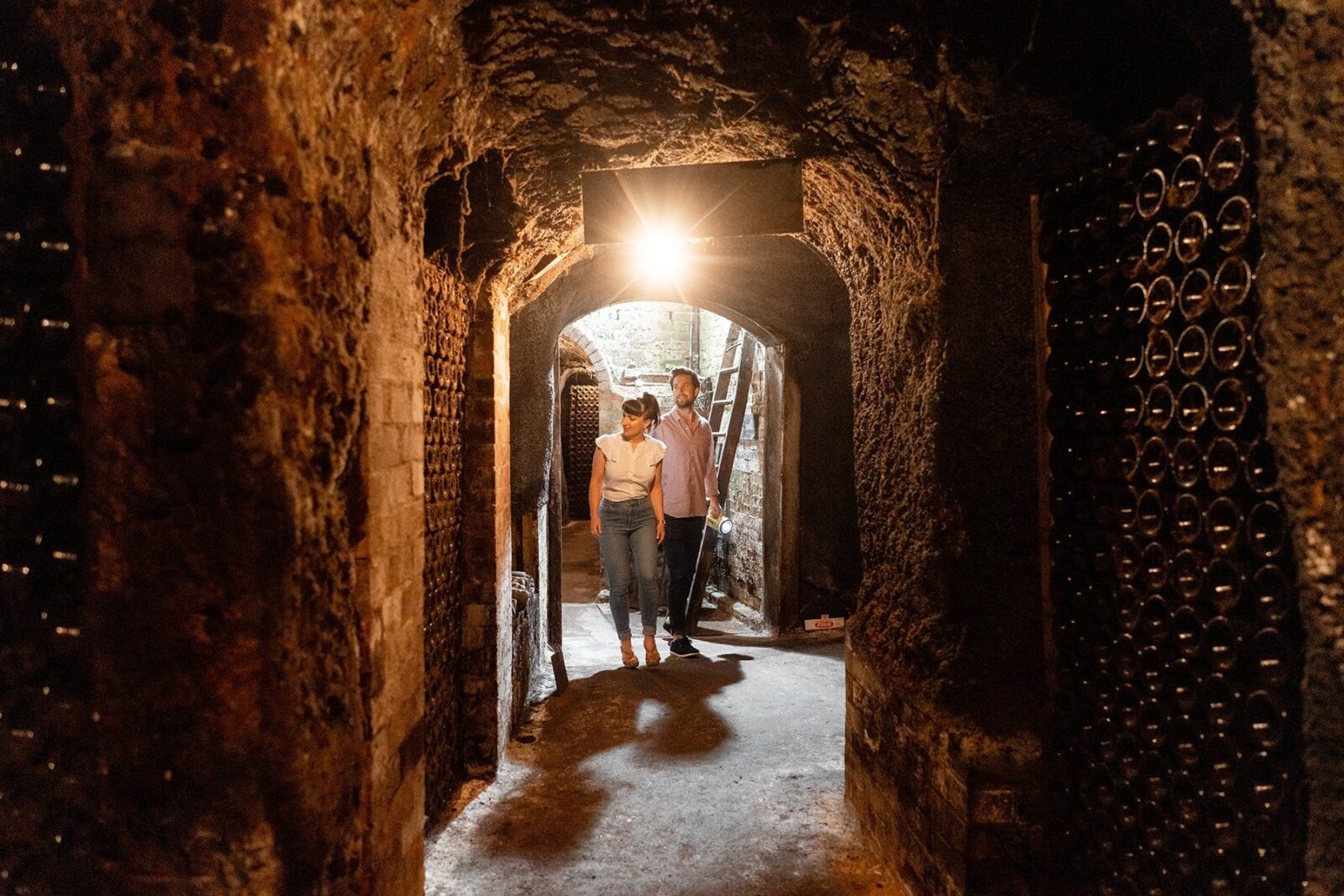 A man and a woman exploring the underground cellars