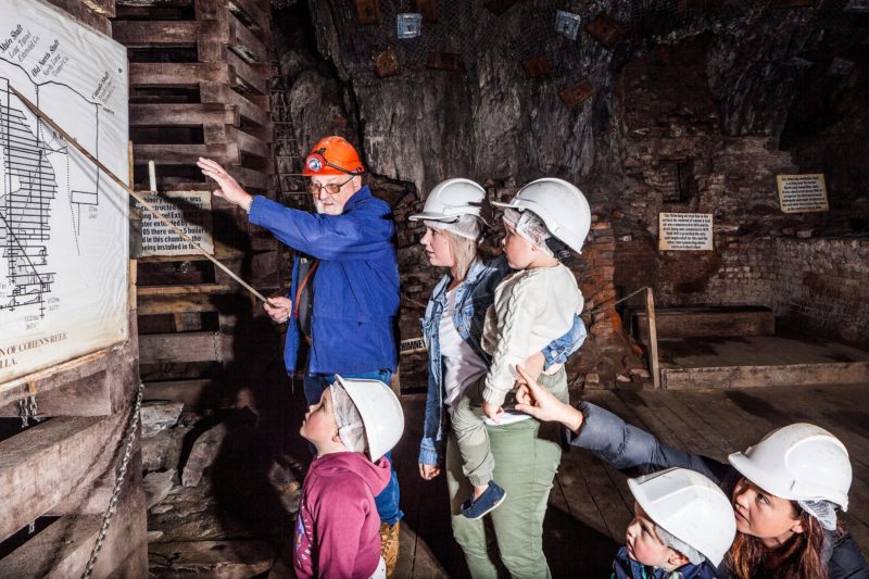 Mine Manager Geoff Anderson showing a family a map of the mine while deep underground
