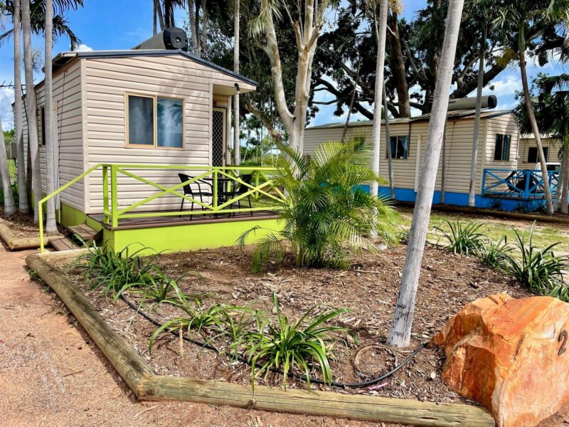 A photo of the outside of a chalet at Broome Caravan Park surrounded by palm trees