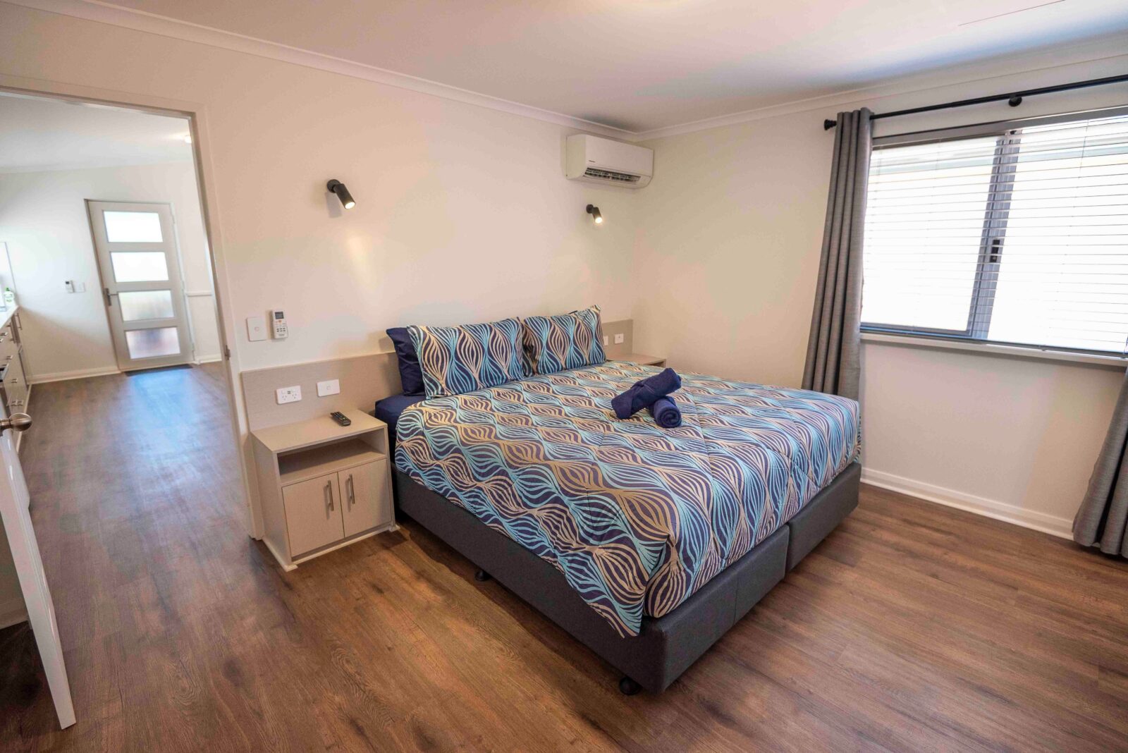 A large master bedroom features a king bed, air conditioning and night stands with USB charging port
