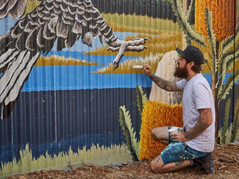 Brenton See painting mural onto shed