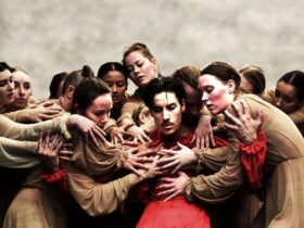 Architect of the Invisible dancers in a group embrace.