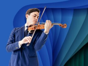 Benjamin Bailman is playing violin wearing a dark blue suit
