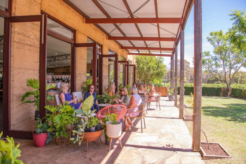 verandah with stylish outdoor furniture and people eating