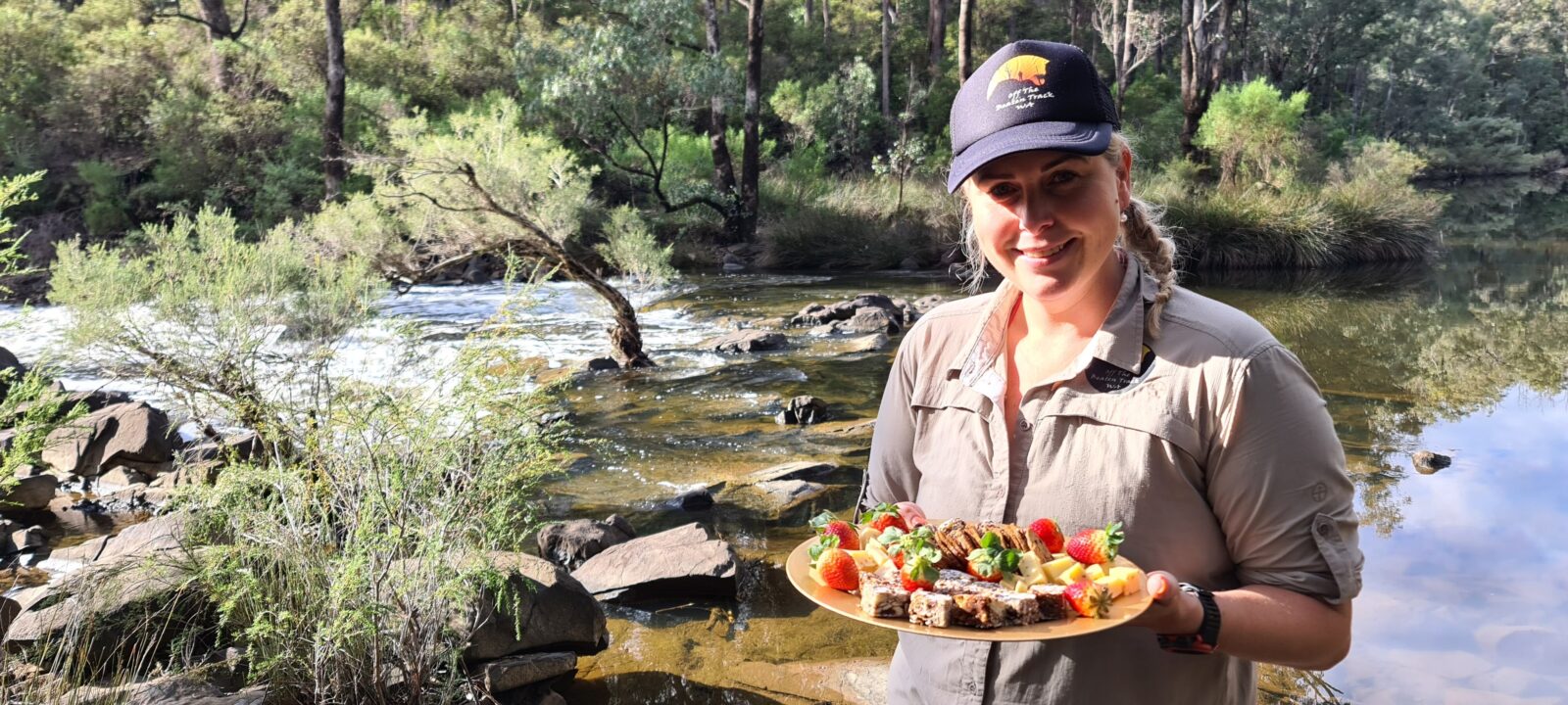 gourmet morning tea platter with smiling friendly guide and river in background